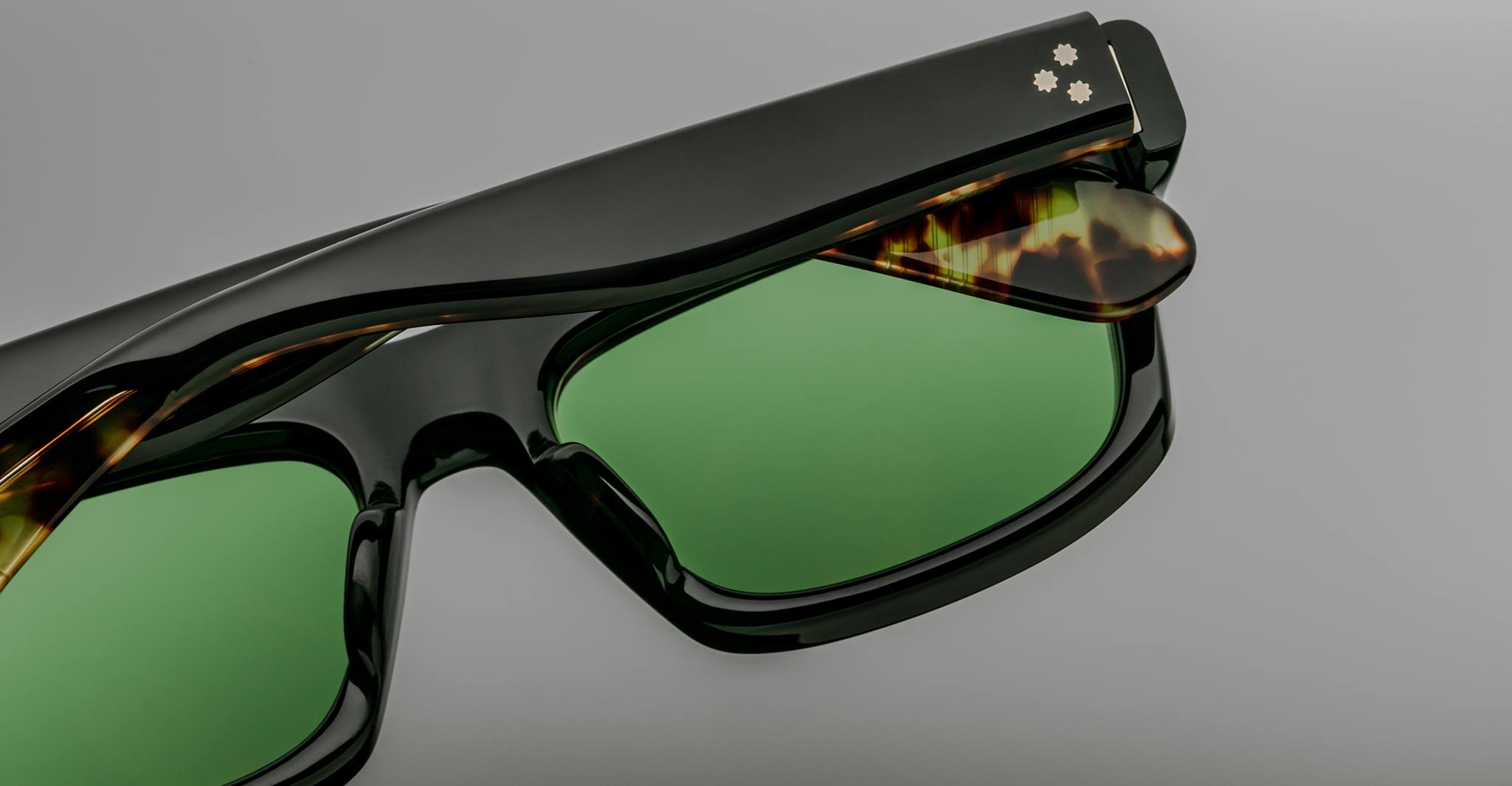 Close-up of Jacques Marie Mage Cleavon sunglasses, black and tortoiseshell frame with green lenses, front angle.