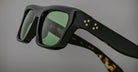 Jacques Marie Mage Cleavon black sunglasses, close-up view, featuring green lenses and white dot accents on the frame.