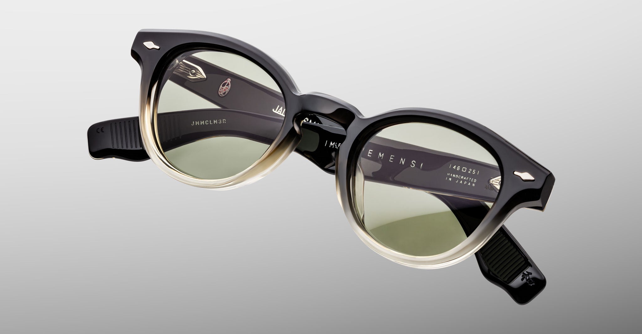 Jacques Marie Mage Clemens in Black Fade eyeglasses black to beige gradient frame with green-tinted lenses, shown from the front.