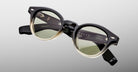 Jacques Marie Mage Clemens in Black Fade eyeglasses black to beige gradient frame with green-tinted lenses, shown from the front.