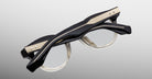 Jacques Marie Mage Clemens in Black Fade eyeglasses with thick black to clear gradient frames, folded, product view from the back.