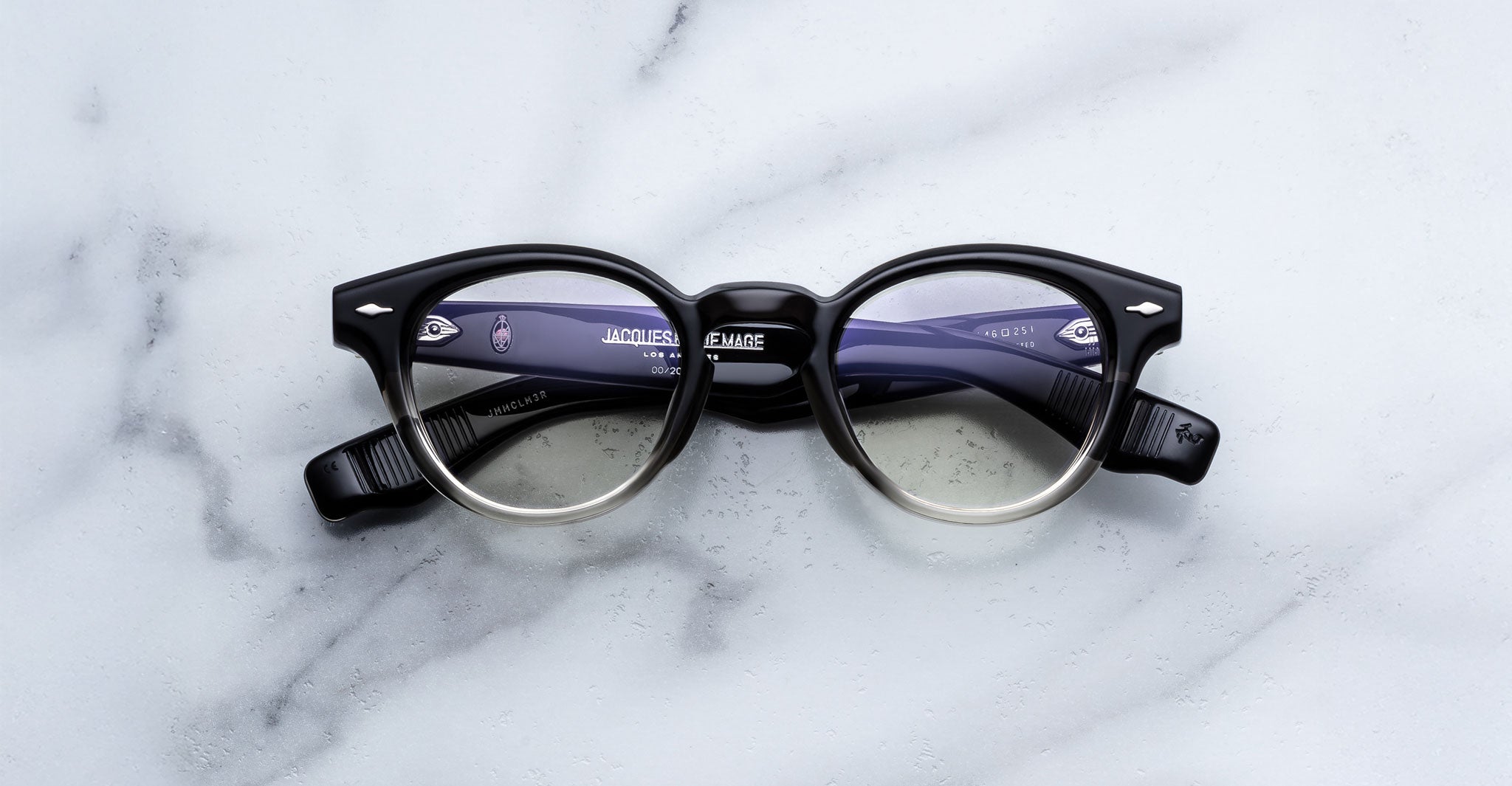 Jacques Marie Mage Clemens in Black Fade round black eyeglasses with clear lower rims, product shown from above.