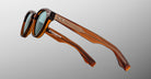 Jacques Marie Mage Clemens in Hickory sunglasses, brown thick frames, green UV-protective lenses, side view.