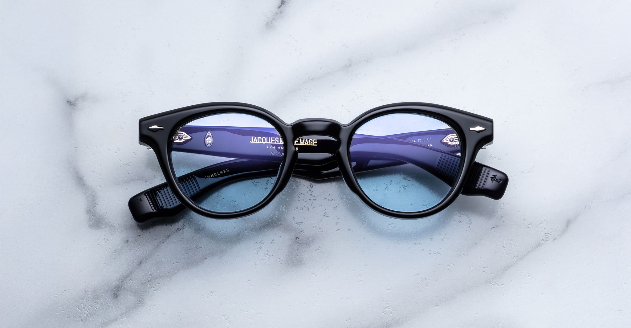 Jacques Marie Mage Clemens in Obscure black round eyeglasses with blue-tinted lenses, top view.