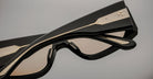 Close-up of Jacques Marie Mage Cliff black sunglasses, gold accents visible on frame, product shown from the front angle.
