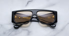 Jacques Marie Mage Cliff sunglasses, black frame with brown lenses, folded, top view.
