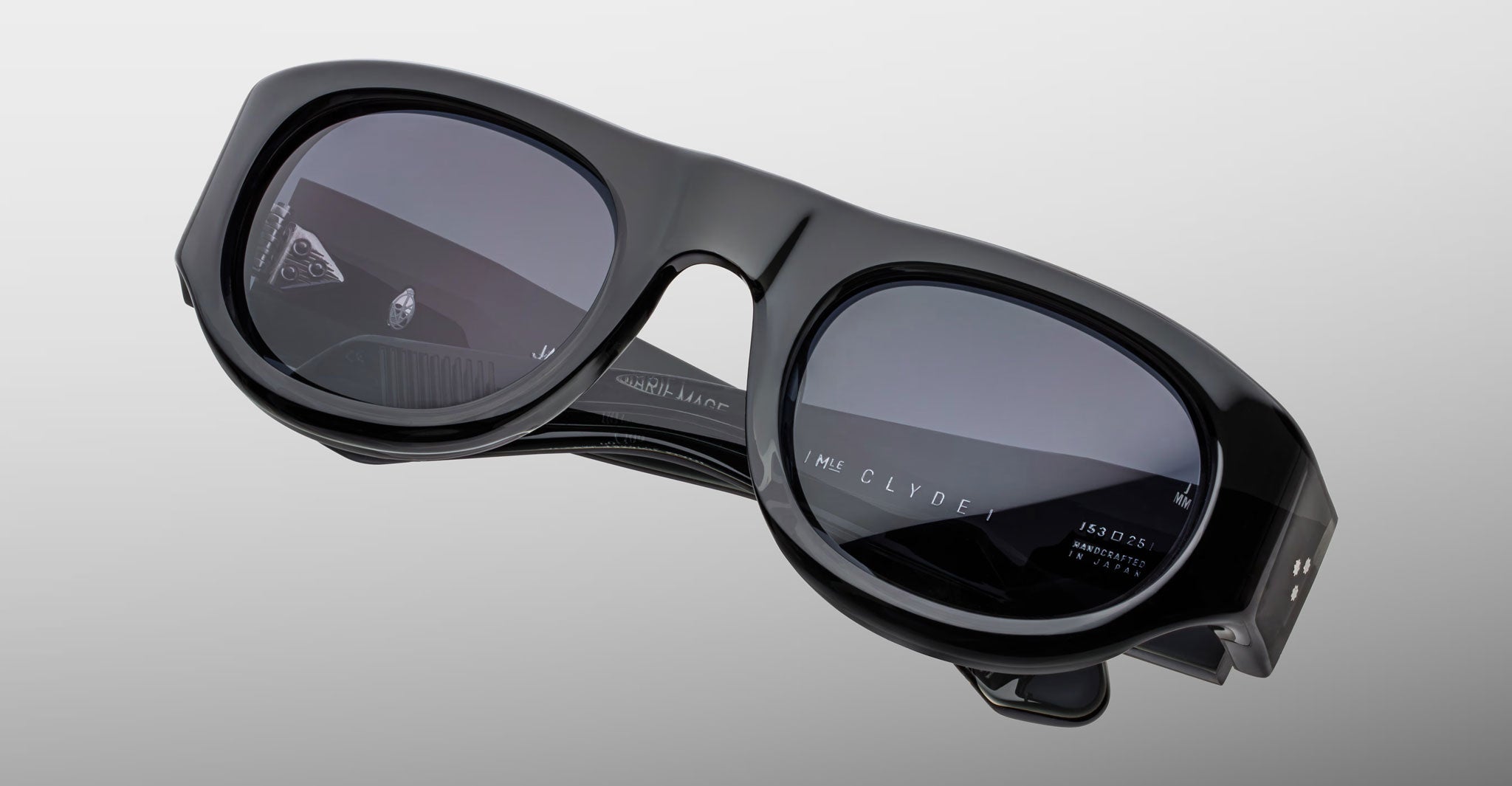 Front view of the Jacques Marie Mage Clyde 2.0 sunglass in Grisaille Black acetate, dark drey lenses, on a light grey background