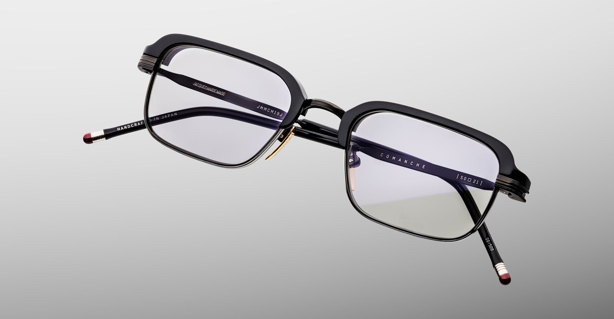 A pair of Jacques Marie Mage Comanche black rectangular eyeglasses with clear lenses and metal temple accents, displayed on a light gray background—a sophisticated limited-edition piece by Jacques Marie Mage.