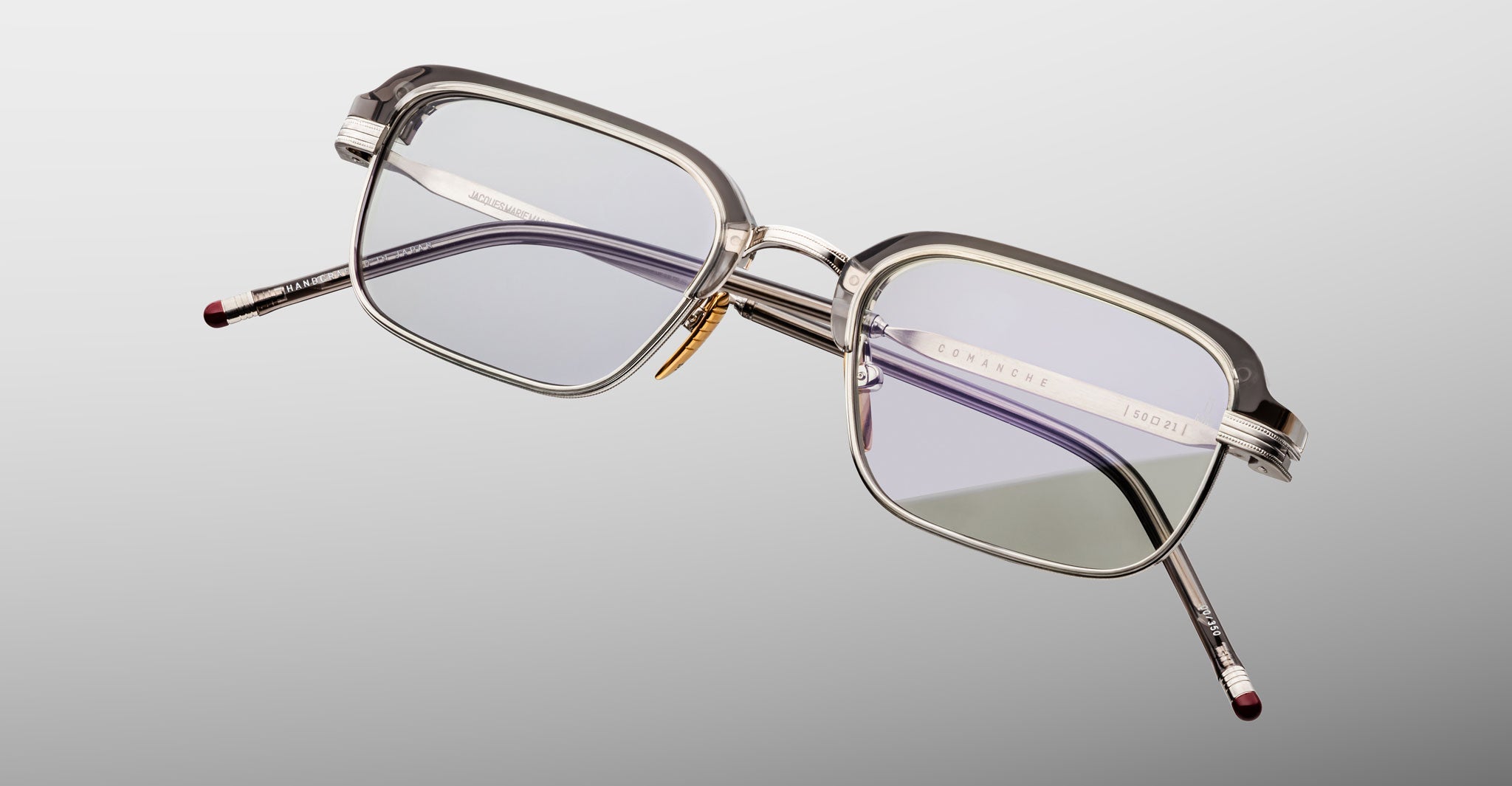 The Jacques Marie Mage Comanche features rectangular, thin silver metal frames and clear lenses, showcased on a light gray background—a sophisticated piece from Jacques Marie Mage’s limited-edition collection.