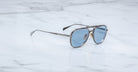 Angled view of Jacques Marie Mage Commander in Antique Silver, featuring an antique silver-tone titanium aviator frame with double bridge, engraved rims, and cool blue lenses with a clean, modern finish.