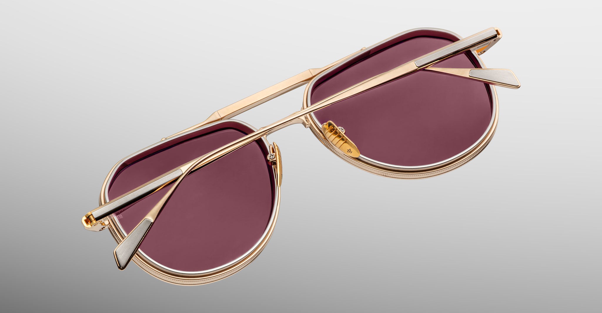 Top-down view of Jacques Marie Mage Commander in Champagne, revealing the light gold-tone titanium frame, double bridge construction, engraved rims, and slender temples with signature inlaid tips.