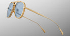 The Jacques Marie Mage Commander sunglasses, featuring gold frames, blue-tinted lenses, thin arms, and a double bridge design, are displayed in close-up against a light gray background.
