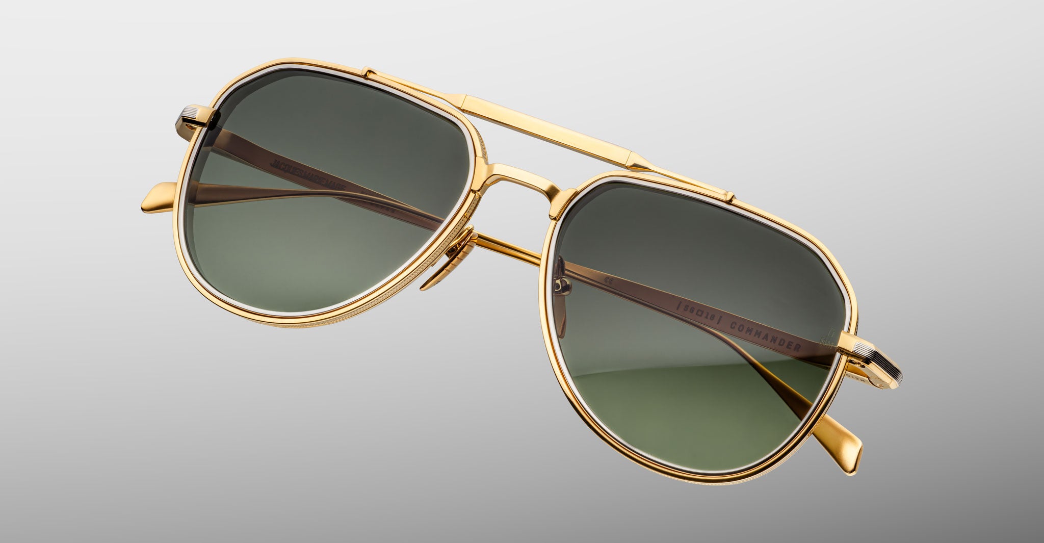 Three-quarter view of Jacques Marie Mage Commander in Musket, showcasing the gold-tone double-bridge frame, engraved aviator rims, and green lenses with a refined, military-inspired silhouette.