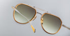 Close-up view of Jacques Marie Mage Commander sunglasses featuring gold and silver metal frames with gradient dark lenses, set against a plain light gray background.