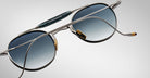 Detailed back view of the Jacques Marie Mage Dasan titanium sunglass in silver with blue gradient lenses on a white background