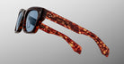 The Jacques Marie Mage Dealan 53 sunglasses feature tortoiseshell-patterned plastic frames and blue-tinted lenses, shown against a plain light gray background.