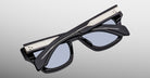 Jacques Marie Mage Dealan 53 black polarized sunglasses with silver accents, folded, top view.