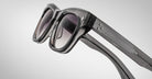 Close-up view of Jacques Marie Mage Dealan 53 sunglasses featuring dark, thick glossy frames with subtle textured arm details and slightly tinted lenses, set against a light gradient background.