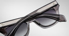 A close-up of two Jacques Marie Mage Dealan 53 black sunglasses with gradient lenses, stacked together, featuring detailed frames with thin silver stripes and metallic corner accents.