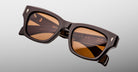 Jacques Marie Mage Dealan 53 sunglasses, front view, featuring bold brown frames and amber lenses.