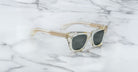 Jacques Marie Mage Dealan sunglasses with clear frames and dark lenses, viewed from above.