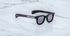 Jacques Marie Mage Dealan black rectangular sunglasses with dark lenses and silver arms, front angle view.