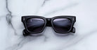 Jacques Marie Mage Dealan black rectangular sunglasses with dark lenses, shown from above.