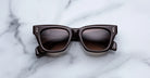 Jacques Marie Mage Dealan black rectangular sunglasses with dark lenses, top view.