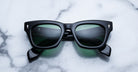 Jacques Marie Mage Dealan black rectangular sunglasses with green lenses, top view.
