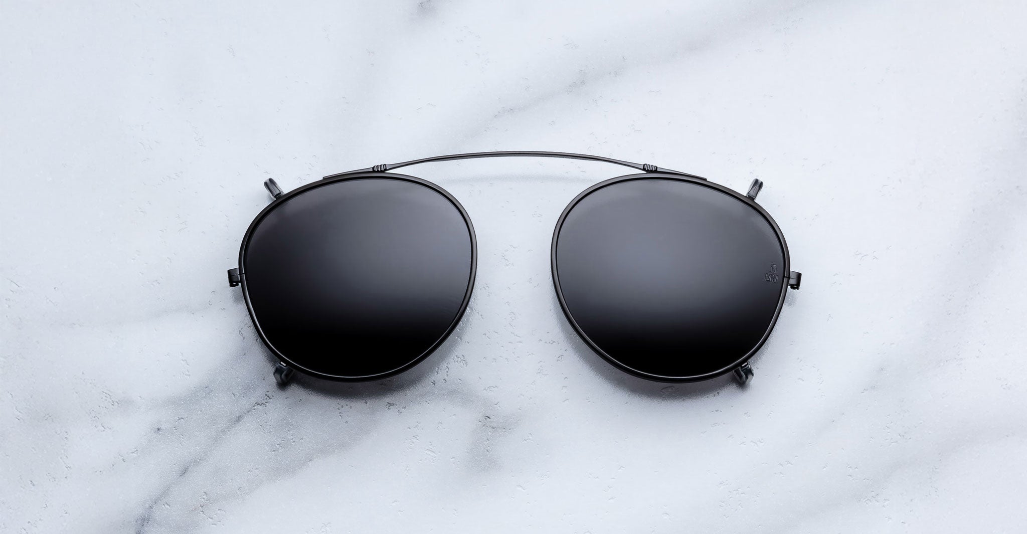 Jacques Marie Mage Demoncey Clip-On sunglasses with black aviator frames and dark lenses, shown from the front.