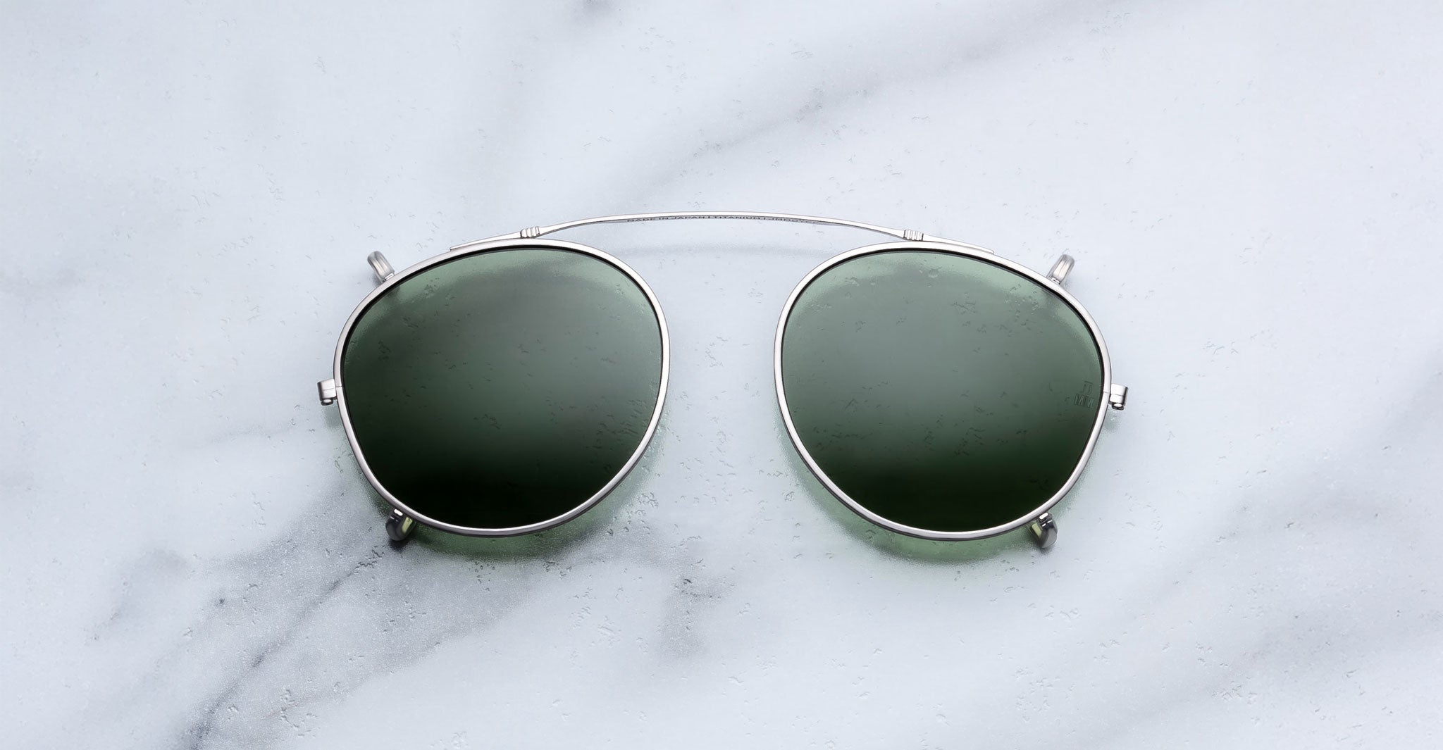 Jacques Marie Mage Demoncey Clip-On sunglasses, dark lenses, thin metal frame, top view.