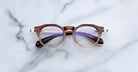 Jacques Marie Mage Desnos round eyeglasses with brown frames and clear lenses, front view.