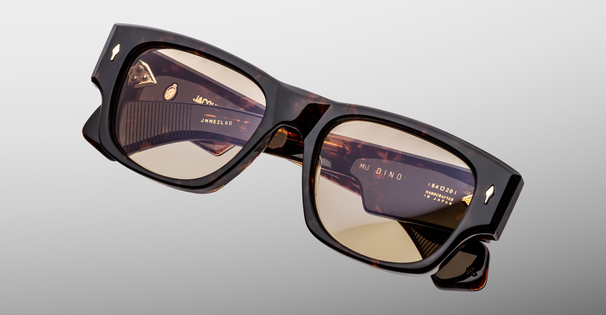 Jacques Marie Mage Dino in Agar tortoiseshell acetate sunglass frame with brown lenses, gold arrowhead pins, and sculptural wide temples, angled top view showing lens and bridge detail