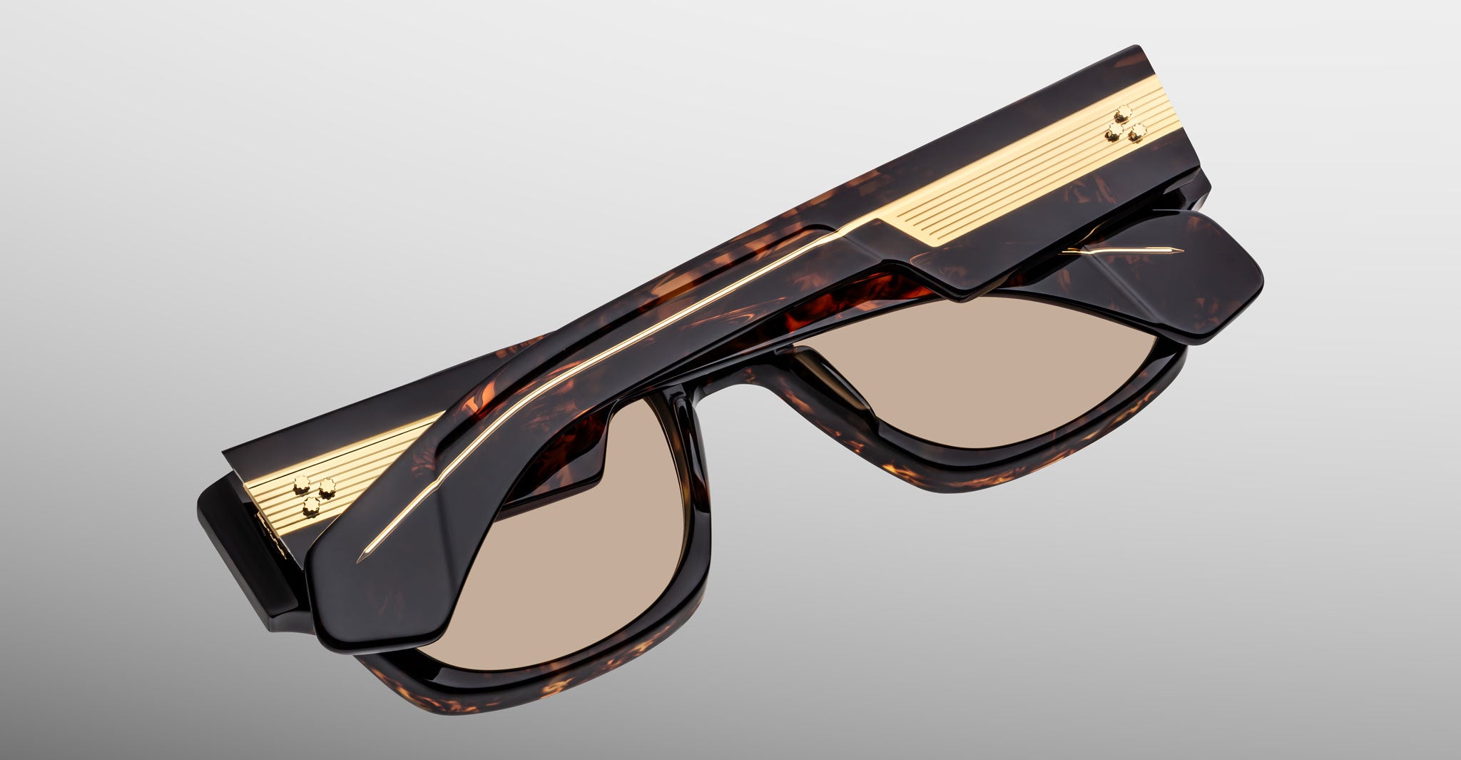 Jacques Marie Mage Dino in Agar tortoiseshell acetate sunglass frame with brown lenses, gold arrowhead pins, and sculptural wide temples, angled view highlighting layered temple construction and wirecore detail