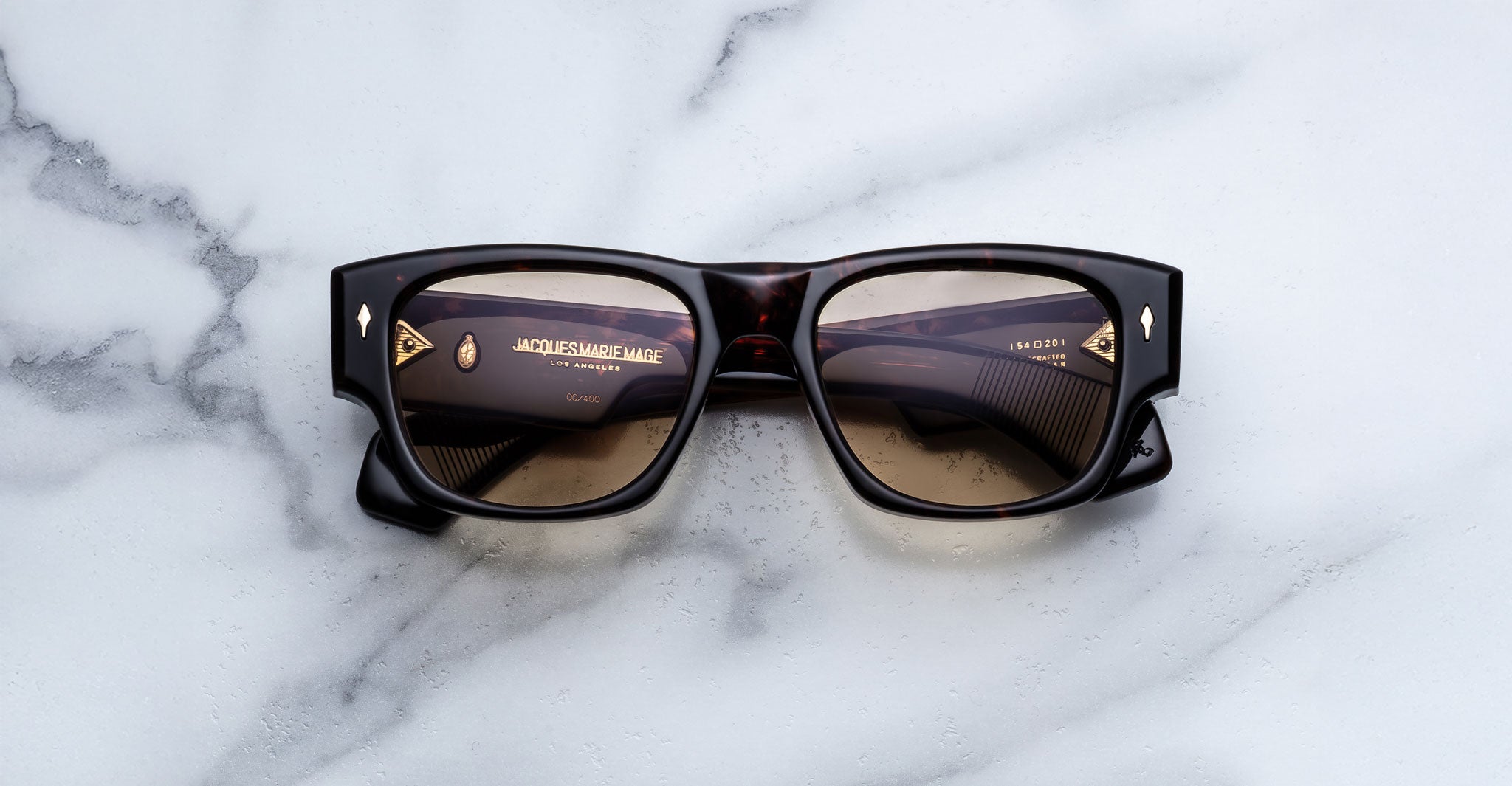 Jacques Marie Mage Dino in Agar tortoiseshell acetate sunglass frame with brown lenses, gold arrowhead pins, and sculptural wide temples, front view