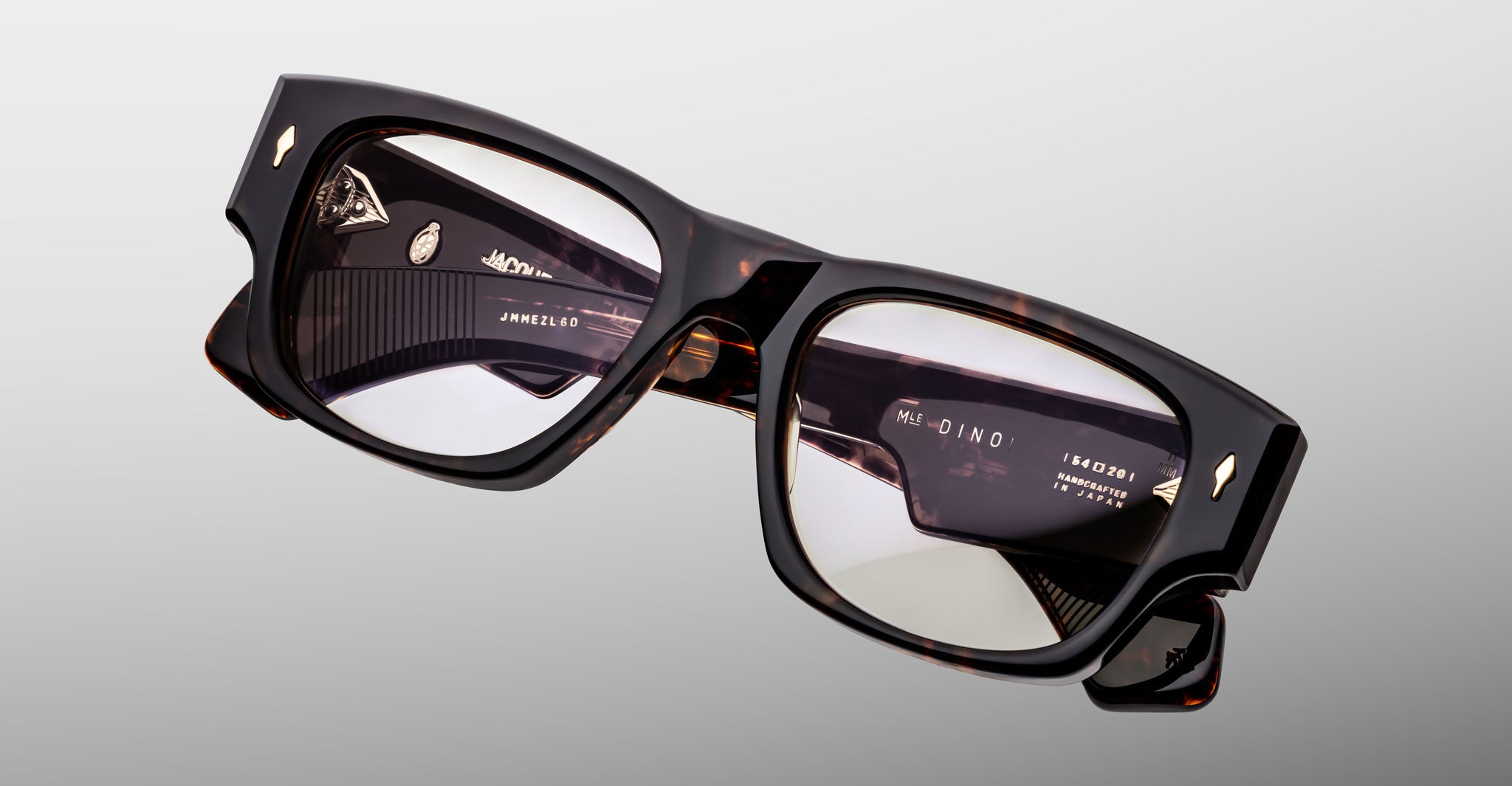 Jacques Marie Mage Dino in Agar tortoiseshell acetate sunglass frame with superlight bronze lenses, gold arrowhead pins, and sculptural wide temples, angled top view showing lens and bridge detail