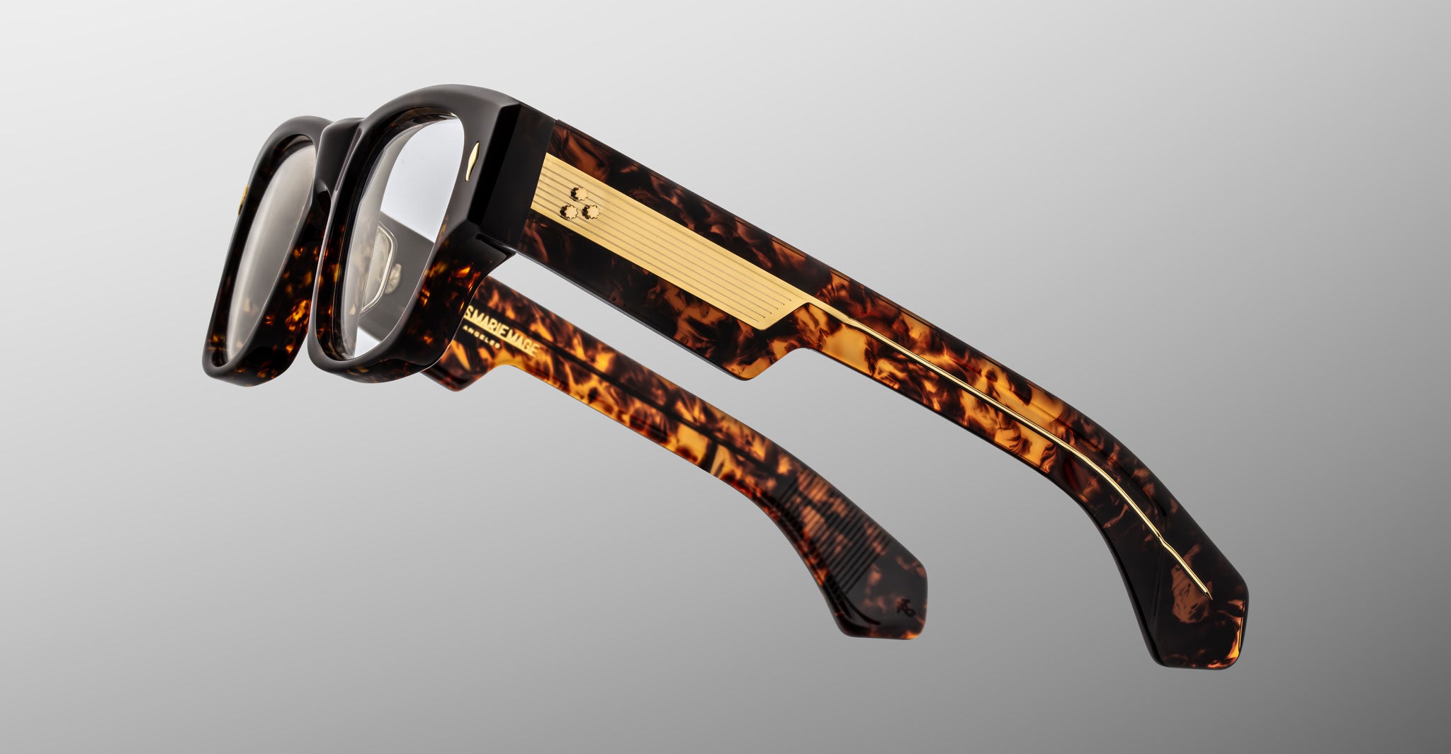 Jacques Marie Mage Dino in Agar tortoiseshell acetate sunglass frame with superlight bronze lenses, gold arrowhead pins, and sculptural wide temples, angled view highlighting layered temple construction and wirecore detail