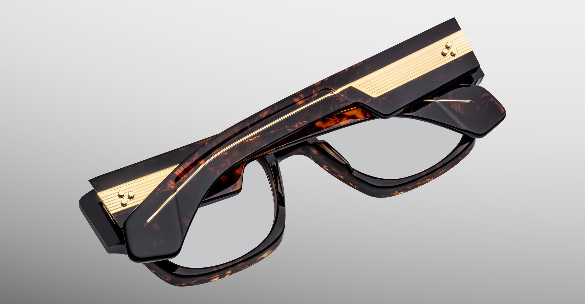 Jacques Marie Mage Dino in Agar tortoiseshell acetate sunglass frame with superlight bronze lenses, gold arrowhead pins, and sculptural wide temples, angled view highlighting layered temple construction and wirecore detail