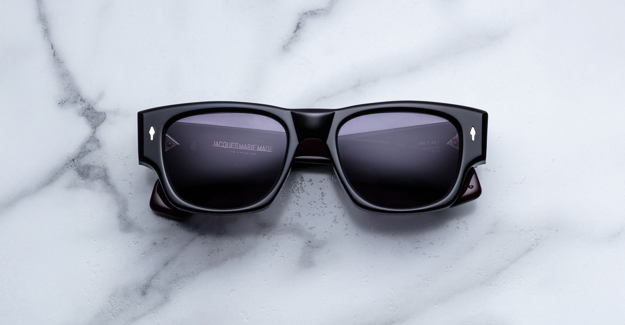 Jacques Marie Mage Dino in Bloodstone black acetate sunglass frame with grey lenses, gold arrowhead pins, and sculptural wide temples, front view