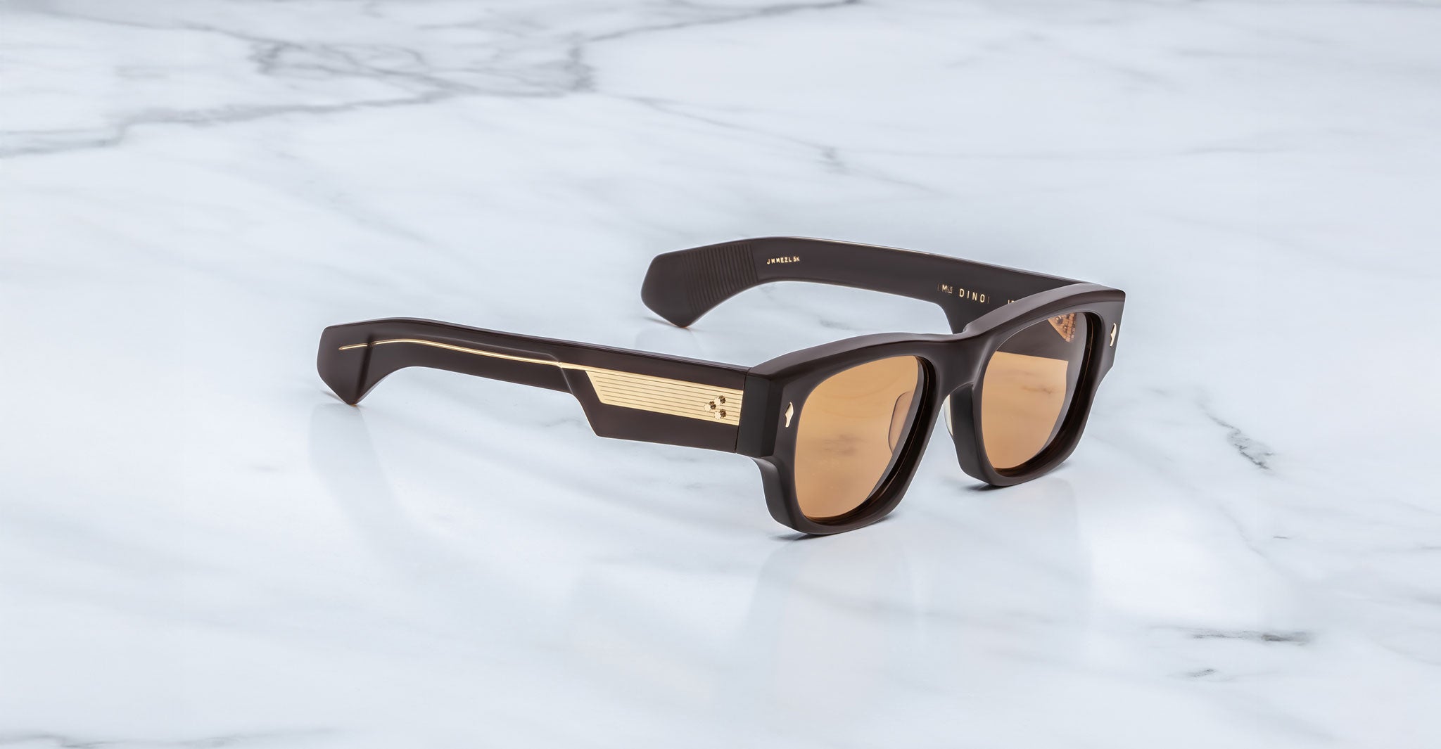 Jacques Marie Mage Dino in Walnut brown acetate sunglass frame with brown lenses, gold arrowhead pins, and sculptural wide temples, three-quarter view showing front and temple profile