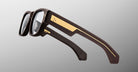Jacques Marie Mage Dino in Walnut brown acetate optical frame with clear lenses, gold arrowhead pins, and sculptural wide temples, angled view highlighting layered temple construction and wirecore detail