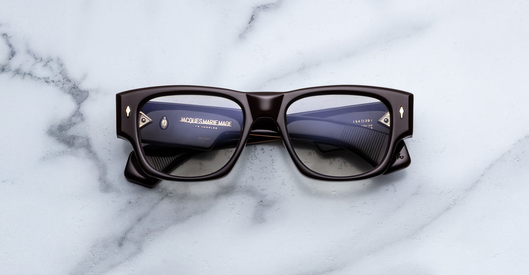 Jacques Marie Mage Dino in Walnut brown acetate optical frame with clear lenses, gold arrowhead pins, and sculptural wide temples, front view