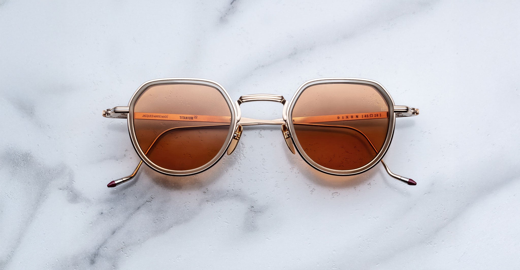 Jacques Marie Mage Dixon sunglasses with gold frames and brown UV lenses shown from above.