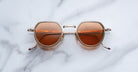 Jacques Marie Mage Dixon sunglasses with gold frames and brown UV lenses shown from above.