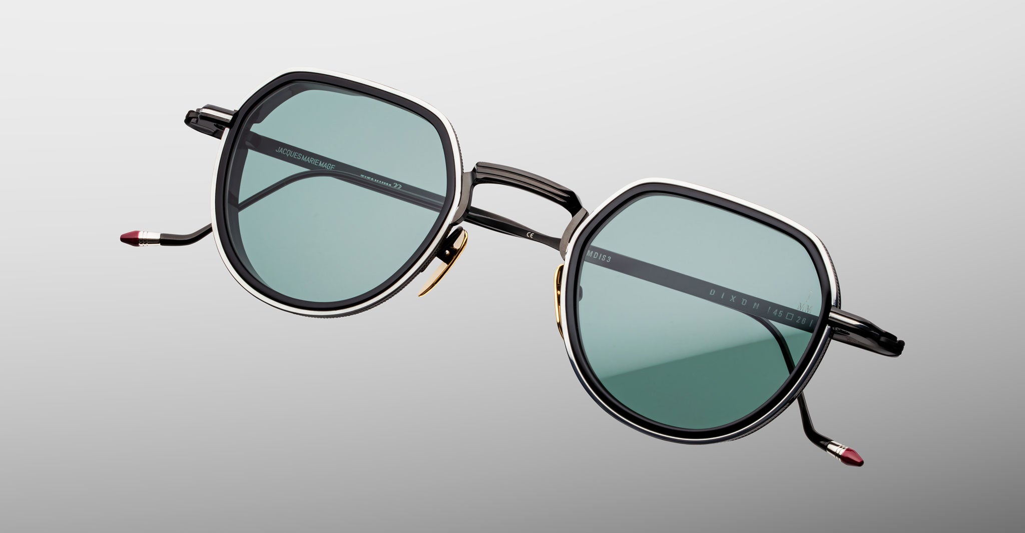 Jacques Marie Mage Dixon sunglasses with hexagonal frames, green lenses, and black arms shown from the front.