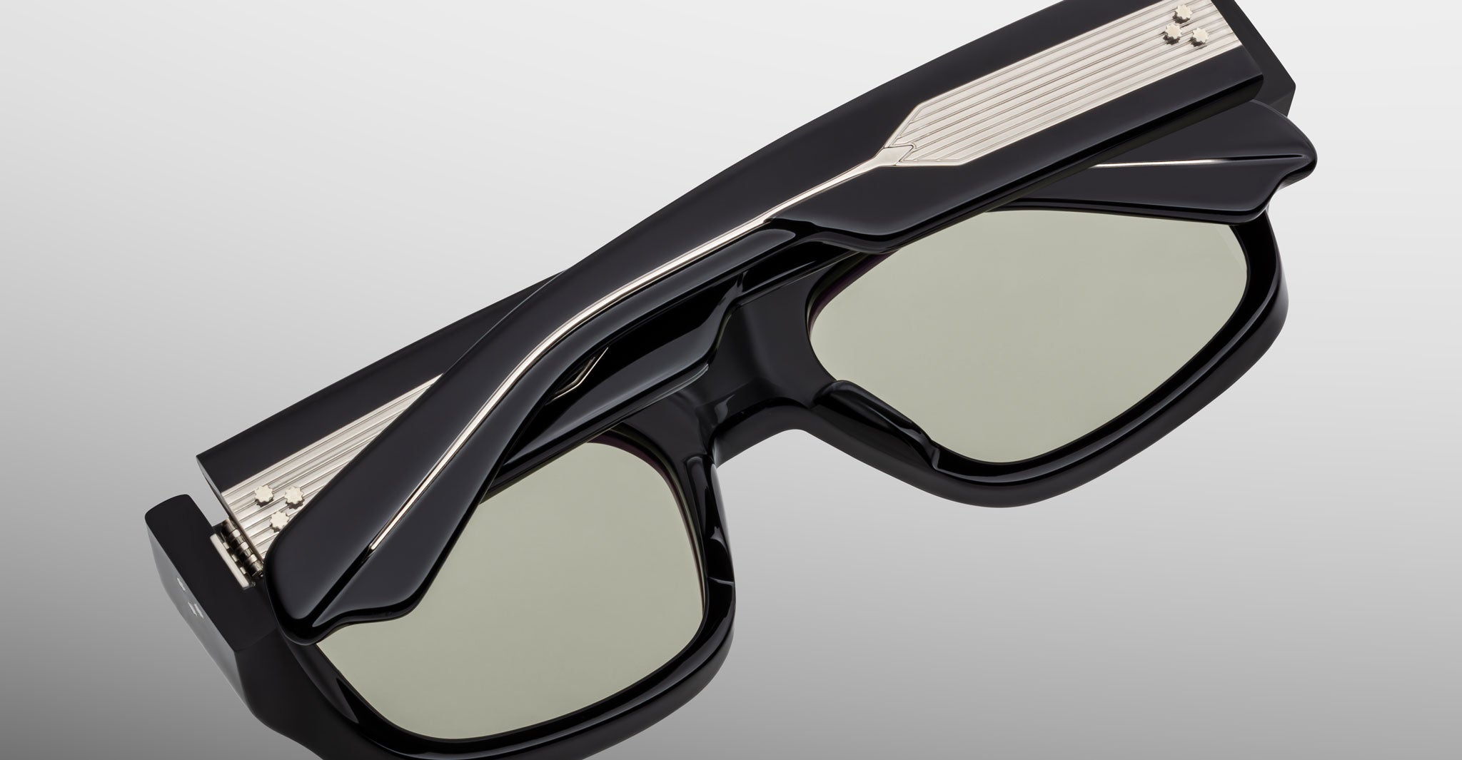 The Jacques Marie Mage Donat is a pair of black, rectangular sunglasses with thick frames and metallic accents on the temples, shown against a plain light gray background.