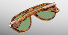 Jacques Marie Mage Donnybrooke in Vintage Tortoise sunglasses, folded, tortoiseshell frame with green lenses and gold accents, shown from a top angle.