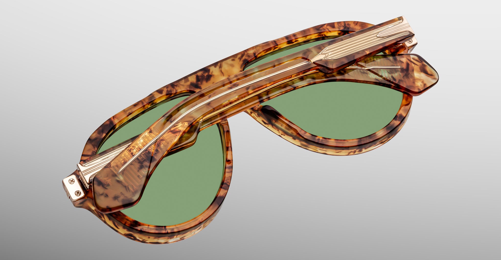 Jacques Marie Mage Donnybrooke in Vintage Tortoise sunglasses, folded, tortoiseshell frame with green lenses and gold accents, shown from a top angle.