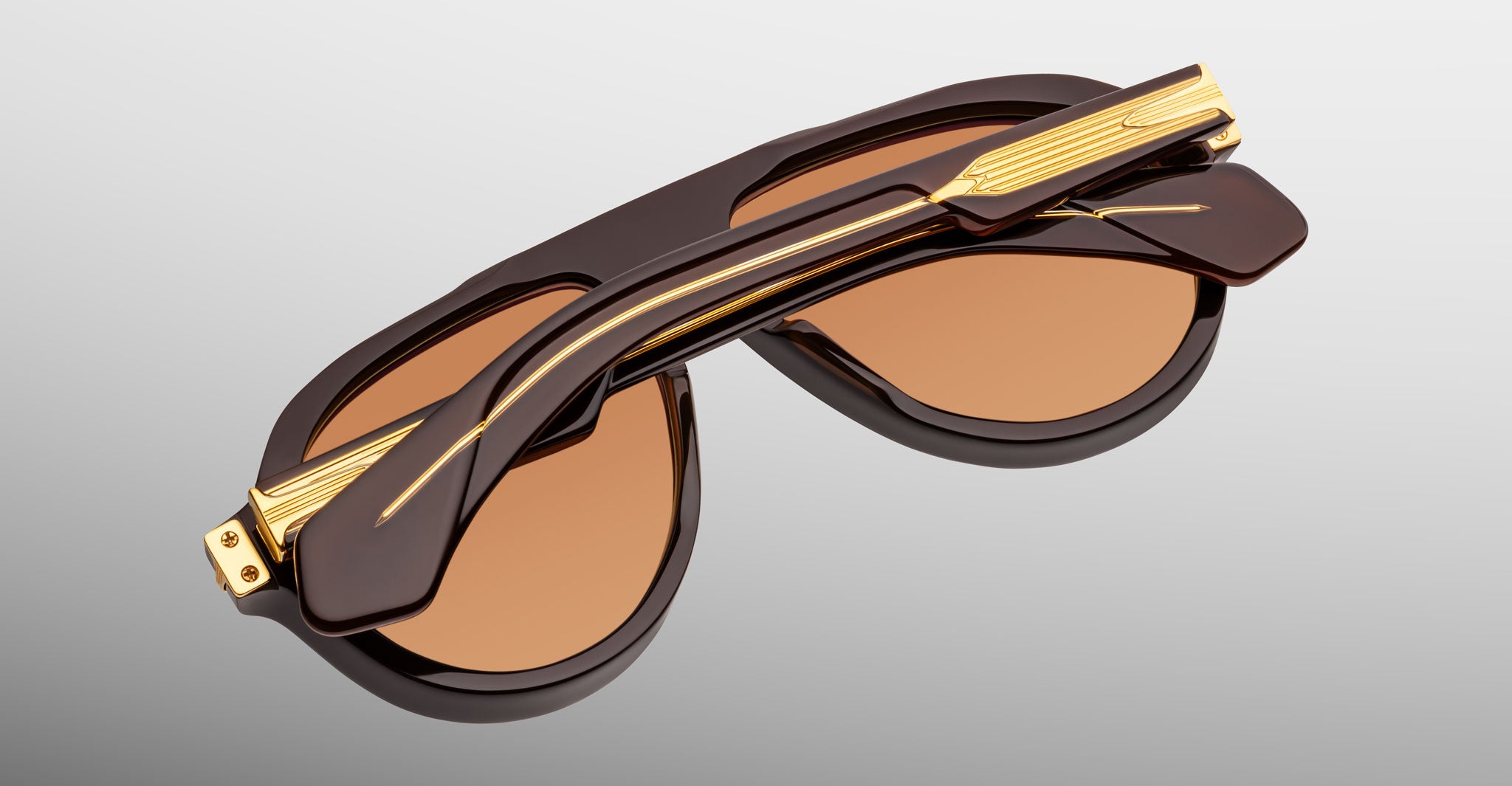 Jacques Marie Mage Donnybrooke in Walnut sunglasses, folded, brown frame with gold accents and UV-protected brown-tinted lenses, back view.