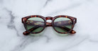 Jacques Marie Mage Dr Dream in Baltic tortoiseshell round sunglasses with green lenses, front view.